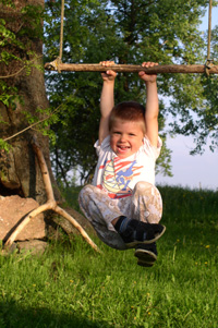 photo of boy playing on swing